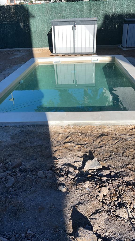 Colocación e instalación de césped artificial de alta calidad junto al borde de la piscina
